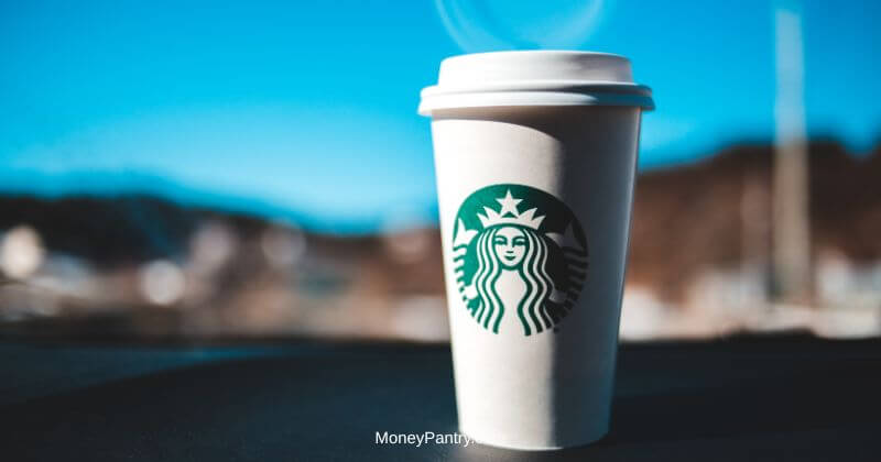 Person holding a coffee cup at a café counter — Starbucks birthday reward free drink