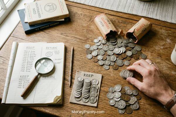 Person sorting coins from open paper rolls into keep and return piles on a wooden table. 